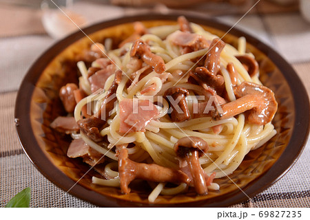Spaghetti pasta with chanterelles and ham 69827235
