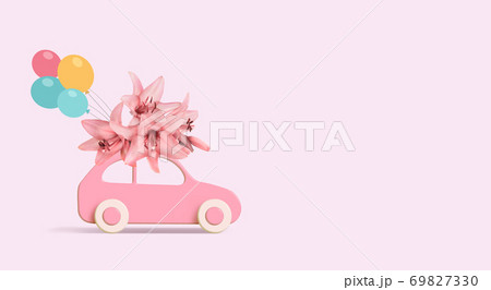 Pink car with bunch of flowers on a roof and baloons on pink background. Copy space. Pink car with bunch of flowers on a roof and baloons on pink background. Copy space. 69827330