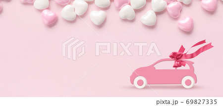 Pink car with gift bow on a pink background with hearts Pink car with gift bow on a pink background with hearts 69827335