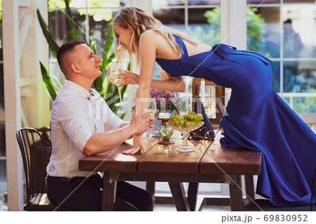 romantic dinner. girl with glass stands on table. romantic dinner. girl with glass stands on table. 69830952