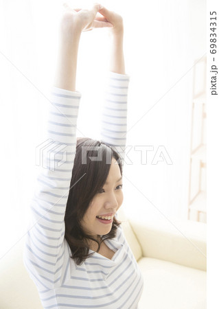 伸びをする女性 69834315