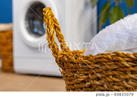 Washing machine with laundry on blue wall background Washing machine with laundry on blue wall background 69835079