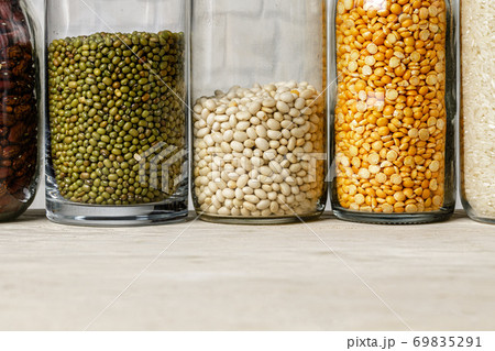 Raw cereals or beans in glass jars close up. Vegan and vegetarian food. Raw cereals or beans in glass jars close up. Vegan and vegetarian food. 69835291