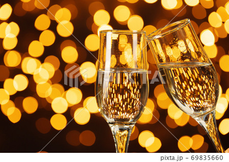 Two glasses of Champagne against bokeh lights background Two glasses of Champagne against bokeh lights background 69835660