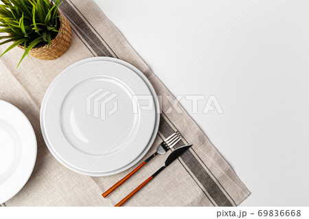 Fork, knife and plate on towel. Isolated on white background. Fork, knife and plate on towel. Isolated on white background. 69836668