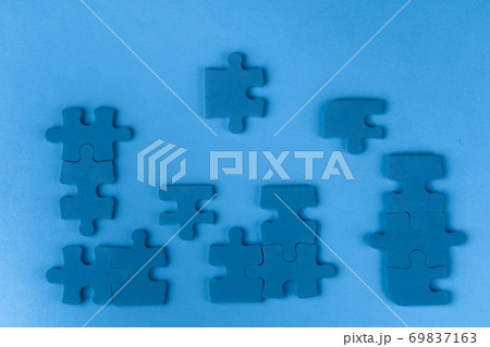 Puzzle pieces on classic blue background, top view Puzzle pieces on classic blue background, top view 69837163