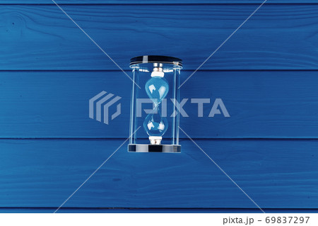 Top view of an hourglass flat lay on classic blue background 69837297