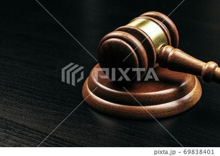 Judge's gavel on wooden table in dark 69838401