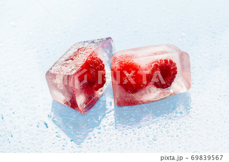 Ice cubes with frozen berries inside close up 69839567