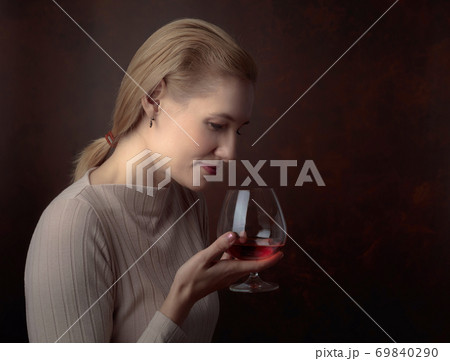 Portrait of a beautiful woman with glass of brandy. 69840290