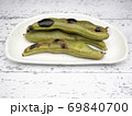 白い木製テーブル上の白いお皿の上の焼きソラマメ 69840700