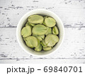 白い木製テーブル上の白いポットに入れた茹でソラマメ 69840701