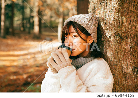 冬の屋外でホットコーヒーを飲む女性 69844158