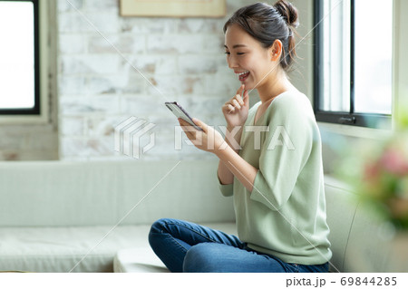 笑顔でスマートフォンを見る女性 69844285