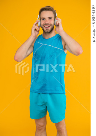Man handsome unshaven sportsman listening music Man handsome unshaven sportsman listening music 69844397
