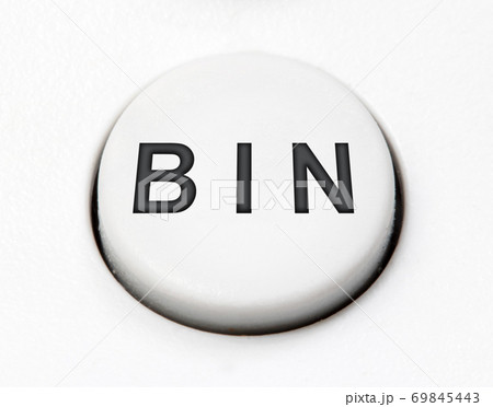 A white round button switch - bin, close up. Control mechanical key for delete on control device. A white round button switch - bin, close up. Control mechanical key for delete on control device. 69845443