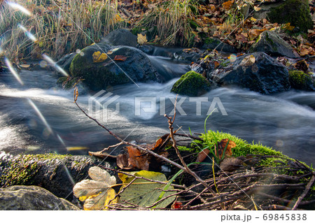 Sun rays shine on a water cascade in the brook. Sun rays shine on a water cascade in the brook. 69845838