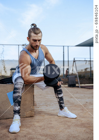 Man doing exercise with dumbbell, street workout 69846104
