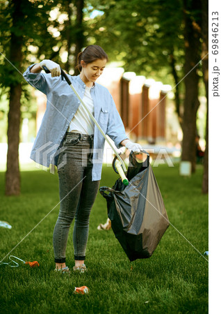Young woman collects garbage in plastic bag 69846213