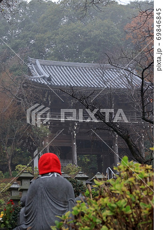 赤い頭巾をかぶった地蔵とお寺 69846845