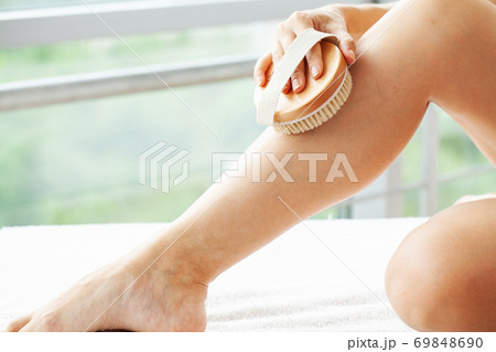 Beautiful young woman with massage brush in bathroom 69848690