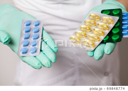 Close up of female doctor holding pill for men health Close up of female doctor holding pill for men health 69848774