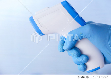 Hand holding infrared thermometer to measuring temperature. Hand holding infrared thermometer to measuring temperature. 69848992