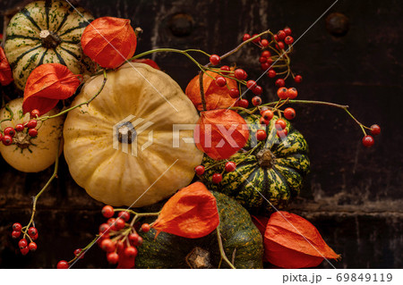 Handmade wreath of small pumpkins and zucchini on a vintage door Handmade wreath of small pumpkins and zucchini on a vintage door 69849119