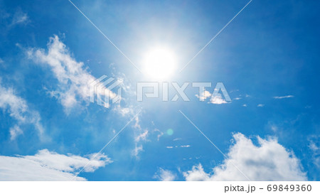 Nature background of clouds with clear blue sky background and sun with lens flare. 69849360