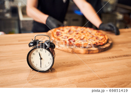 Close up alarm clock with pizza and backer Close up alarm clock with pizza and backer 69851419