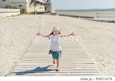 Little girl running on the beach of ocean Little girl running on the beach of ocean 69851679