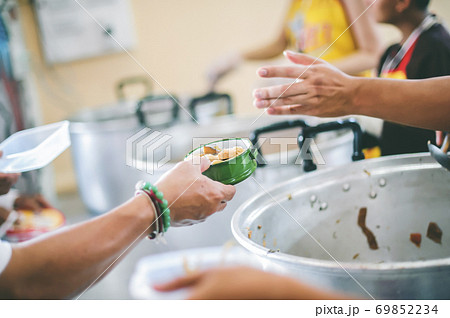 Poor people receive donated food from donors Poor people receive donated food from donors 69852234