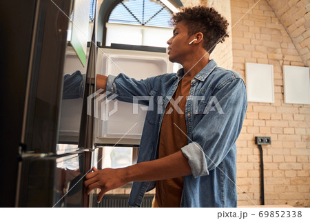Male standing in front of an fridge Male standing in front of an fridge 69852338