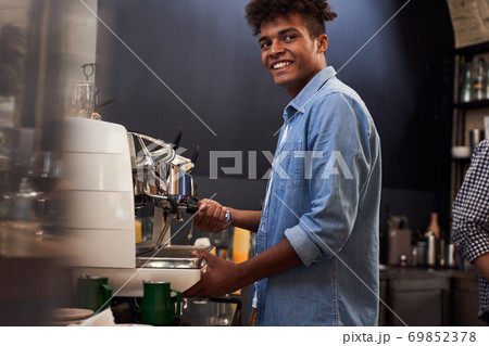 Barista looking at his clients with a satisfied smile 69852378