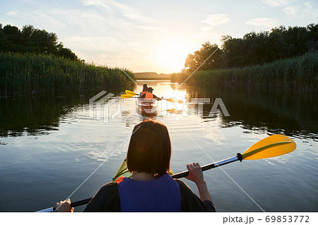 Group of happy tourists walking on kayaks Group of happy tourists walking on kayaks 69853772