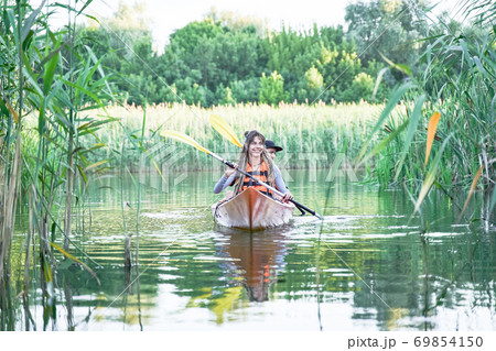 Female and male friends kayaking on river Female and male friends kayaking on river 69854150