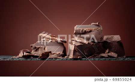 Black chocolate on a brown background. 69855024