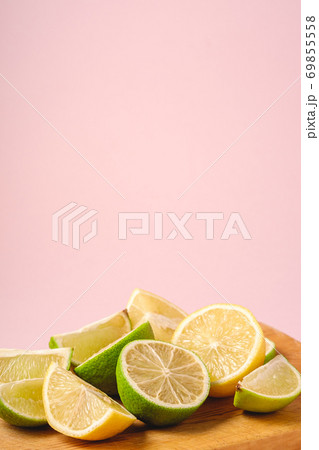 Fresh tasty lemon and lime citrus fruits slices on pink background 69855558