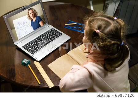 Kid virtual learning with teacher by laptop, tutor teaches preschool child during quarantine due to coronavirus. 69857120