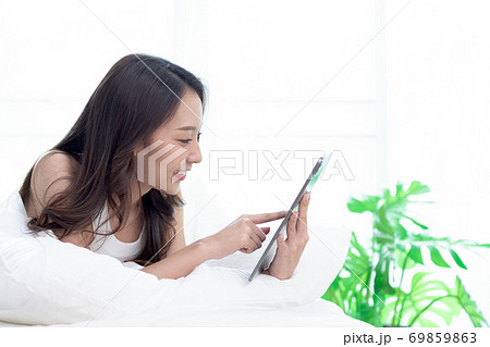 Asian woman shopping online on tablet.Check and working online. 69859863