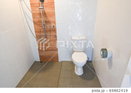 toilet room - interior of simple half bathroom with toilet bath with shower, a white sanitary ware 69862419