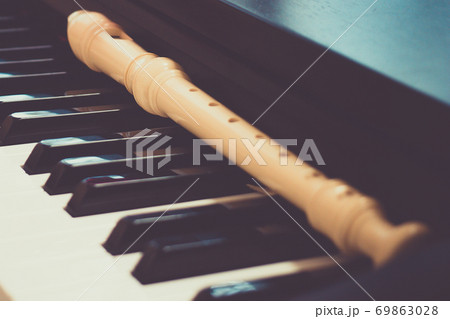 Block flute rest on a piano keyboard. classic music concept Block flute rest on a piano keyboard. classic music concept 69863028