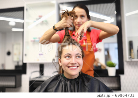 Female client sits in chair in hairdressing salon. 69864733