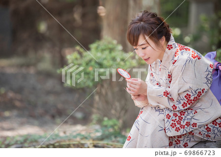 金魚すくいをする女性の写真素材