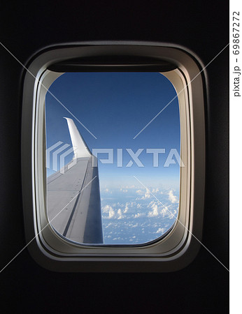 飛行機の窓 飛行機の窓から見える翼、雲の上の雄大な風景の写真素材 [69867272