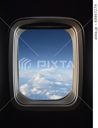飛行機の窓から見える 雲の上の雄大な風景の写真素材