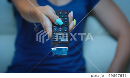 Close up of hand changing TV channels Close up of hand changing TV channels 69867631