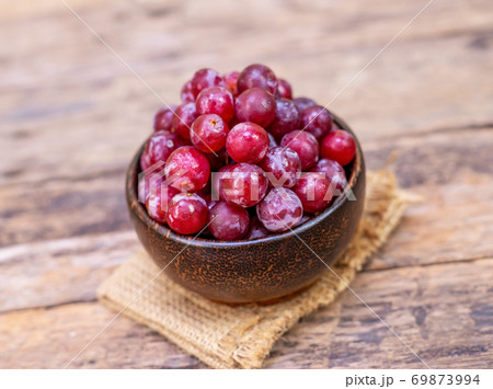 Red grape fruit in wooden bowl on blurred Red grape fruit in wooden bowl on blurred 69873994