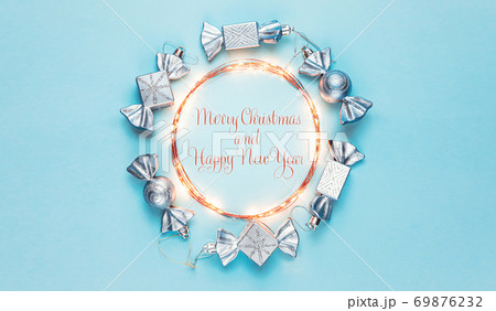 New year 2021. Merry Christmas and Happy Holidays greeting card. Christmas composition. Silver decorations on pastel blue background. Winter, new year concept. Flat lay, top view, copy space 69876232