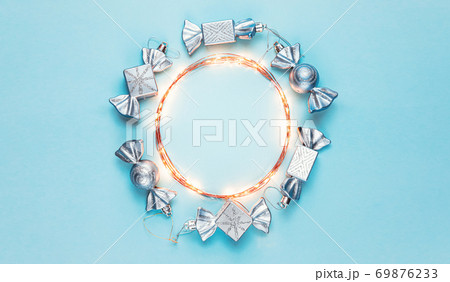 New year 2021. Merry Christmas and Happy Holidays greeting card. Christmas composition. Silver decorations on pastel blue background. Winter, new year concept. Flat lay, top view, copy space New year 2021. Merry Christmas and Happy Holidays greeting card. Christmas composition. Silver decorations on pastel blue background. Winter, new year concept. Flat lay, top view, copy space 69876233